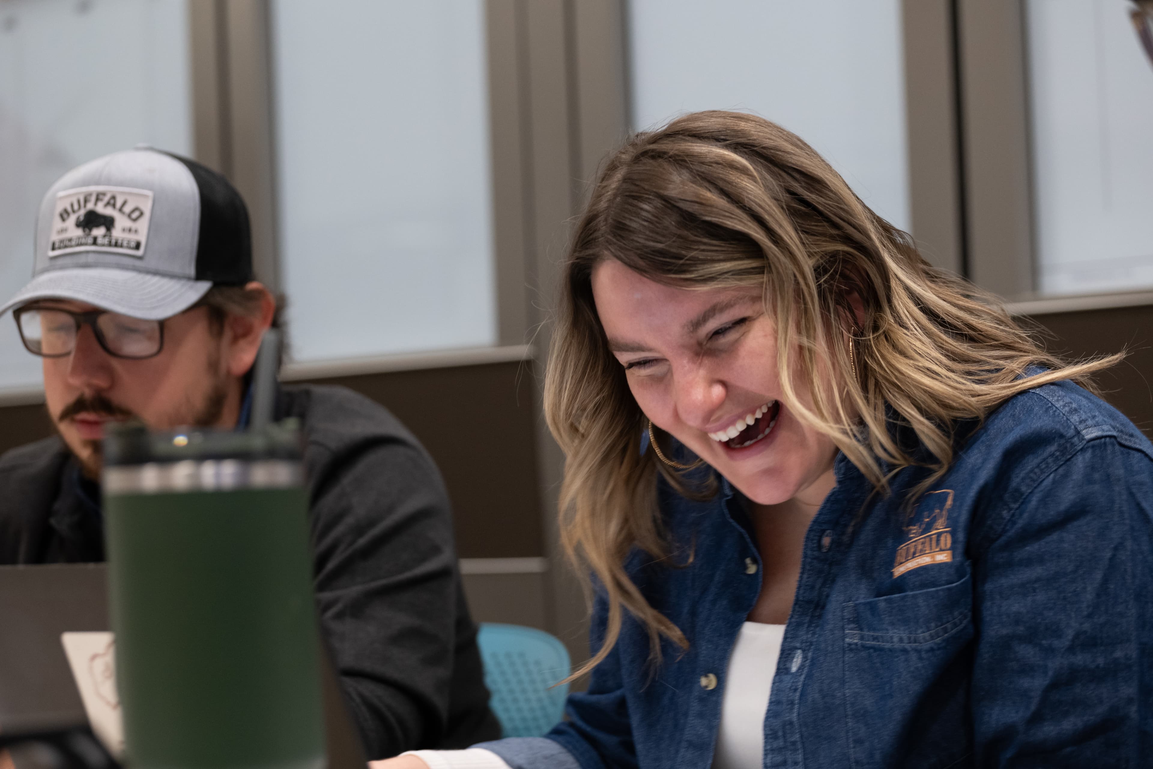 An employee laughing in a team meeting